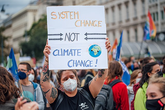 Protester holding a banner with the message System change not climate change 51525653745 - Σόλων ΜΚΟ